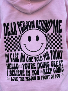 BE KIND (front): DEAR PERSON BEHIND ME (back), pink hoodie with black graphic